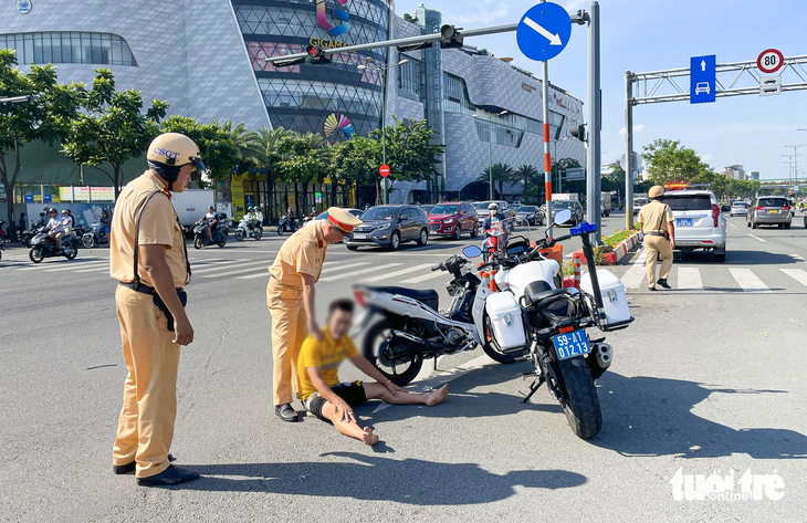 Các chiến sĩ Đội cảnh sát giao thông Hàng Xanh khuyên ngăn nam thanh niên - Ảnh: LÊ PHAN