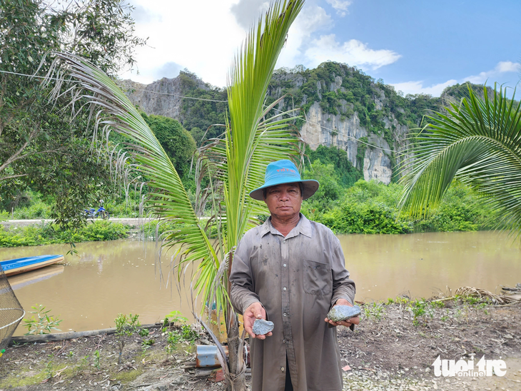 Ông Lâm Văn Tâm cầm trên tay 2 cục đá, &quot;tố&quot; nhà máy Insee đã nổ mìn làm văng 2 cục đá vào nhà ông cách nay 7 ngày - Ảnh: BỬU ĐẤU