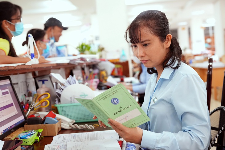 Bà Phương Thu, chuyên viên văn phòng BHXH TP.HCM, giải quyết thủ tục hành chính cho người dân - Ảnh: HỮU HẠNH