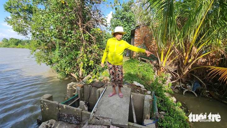 Nước kèm theo bùn đất từ bên ngoài sông chảy vào bên trong ao nuôi thủy sản của bà Huỳnh Thị Á, khiến tôm cá chết sạch