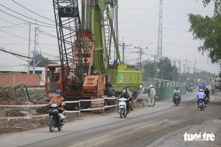 Tất bật thi công tại công trường xây dựng dự án vành đai 3 (tỉnh lộ 15, huyện Củ Chi) - Ảnh: CHÂU TUẤN