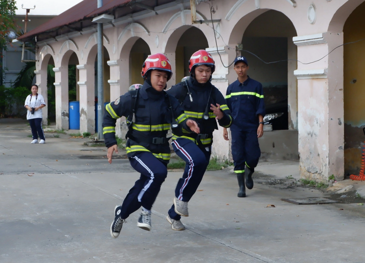 Học sinh vào vai lính cứu hỏa, khẩn cấp lao vào khu vực giả định có sự cố cháy nổ xảy ra - Ảnh: K.ANH