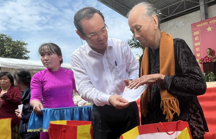 Bí thư Nguyễn Văn Nên tặng quà cho các hộ gia đình khó khăn - Ảnh: T.H.