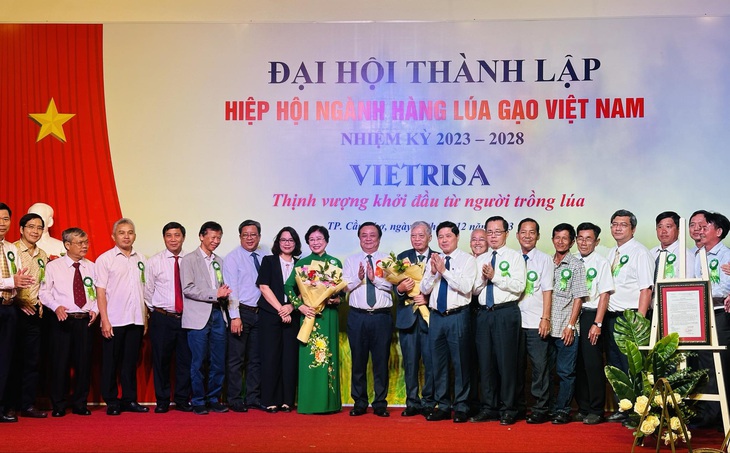 Bộ trưởng Lê Minh Hoan tặng hoa chúc mừng lãnh đạo Hiệp hội Ngành hàng lúa gạo Việt Nam ra mắt chiều 11-12 - Ảnh: HOÀNG TRÍ DŨNG