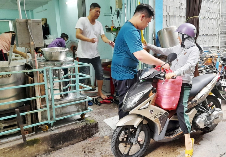 Tình nguyện viên đến nhận cháo đi phát tặng người nghèo