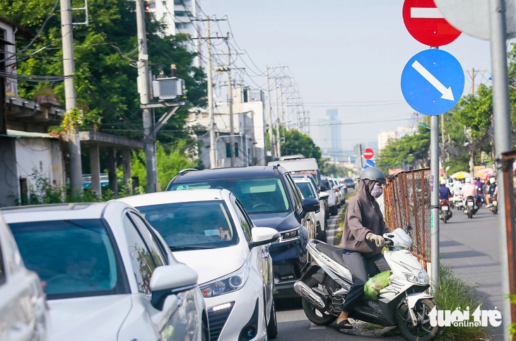 Xe máy luồn lách qua đoạn kẹt ở đường Lương Định Của (TP Thủ Đức) - Ảnh: CHÂU TUẤN