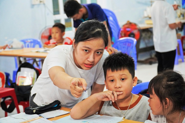 Hiện nay, lớp học đang dạy xuyên suốt các buổi tối trong tuần với số lượng học sinh đông đúc và sự giúp đỡ của hàng chục tình nguyện viên - Ảnh: TRẦN HOÀI