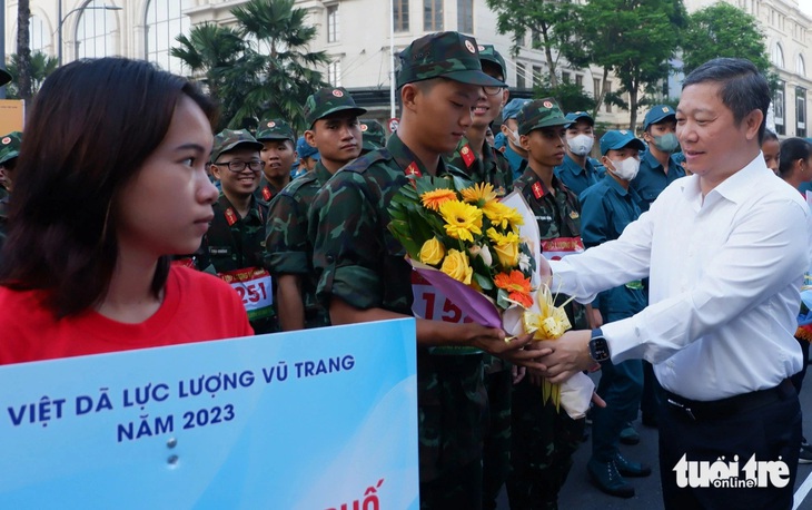 Phó chủ tịch UBND TP.HCM Dương Anh Đức tặng hoa động viên các cá nhân, tập thể tham gia giải chạy - Ảnh: K.ANH