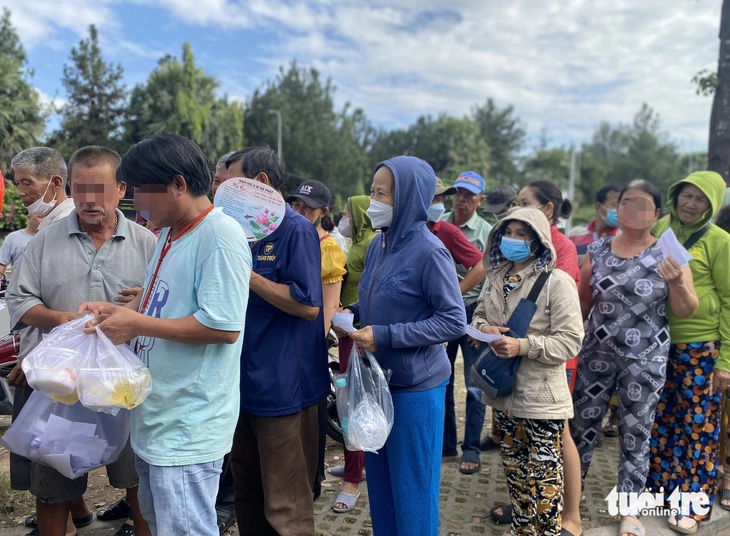 Bệnh nhân, người nhà xếp hàng chờ đoàn từ thiện phát suất ăn miễn phí trước cổng Bệnh viện Ung bướu TP.HCM trưa 18-12. Đa phần một người nhận nhiều suất ăn từ nhiều đoàn từ thiện để dành cho bữa còn lại trong ngày - Ảnh: XUÂN MAI