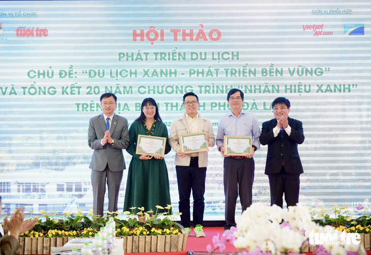 Ông Lê Thế Chữ (tổng biên tập báo Tuổi Trẻ - bìa phải) và ông Đặng Quang Tú (chủ tịch UBND TP Đà Lạt - bìa trái) trao giải cho các tác giả đoạt giải nhất, nhì, ba cuộc thi &quot;Hiến kế phát triển du lịch Đà Lạt bền vững&quot; - Ảnh: QUANG ĐỊNH