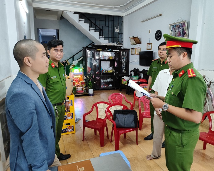 Cơ quan công an tống đạt quyết định đối với Hoàng Ngọc Tiến để điều tra tội tham ô tài sản - Ảnh: H.B.