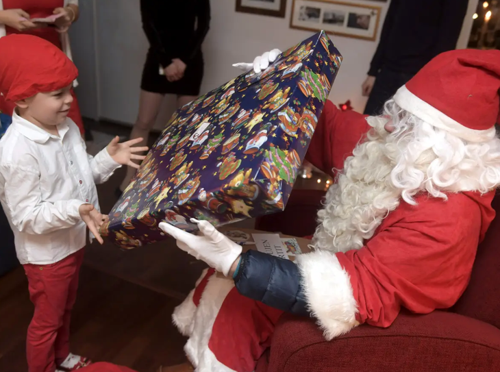 Những truyền thống đón Giáng sinh độc đáo trên thế giới- Ảnh 4. Ông già Noel trao quà cho một em nhỏ Phần Lan - Ảnh: REUTERS