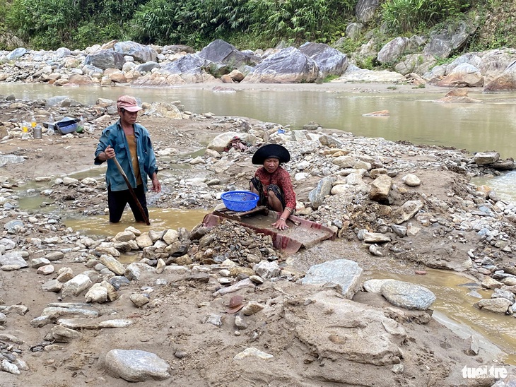 Vợ chồng ông Thêm mót vàng ở suối Đăk Mek. Ảnh: ĐOÀN CƯỜNG