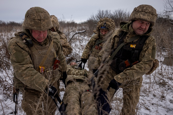 Binh sĩ Ukraine diễn tập chuyển bệnh binh trên thao trường tại vùng Donetsk hôm 24-12 - Ảnh: REUTERS