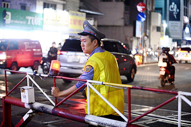 Anh Huỳnh Minh Văn thu gọn các rào chắn di động ngăn xe lưu thông khi có tàu đi qua