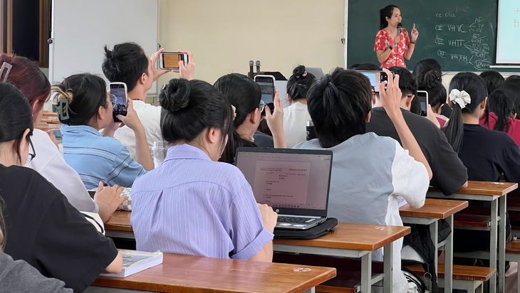 Nhiều sinh viên dùng điện thoại chụp lại nội dung bài giảng - Ảnh: THU GIANG