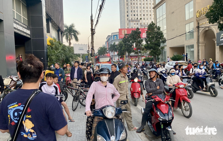 Phút thót tim giải cứu cô gái ngồi vắt vẻo trên tòa tháp 27 tầng- Ảnh 2. Nhiều người dân theo dõi vụ việc - Ảnh: DOÃN HÒA