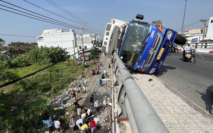 Người dân cùng giúp tài xế xe tải lật trên cầu Kênh Xáng gom cá