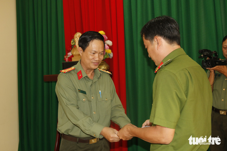 Đại tá Nguyễn Nhật Trường (trái) - phó giám đốc Công an tỉnh An Giang - tặng quà và biểu dương tinh thần dũng cảm của thiếu tá Nguyễn Thành Thi - Ảnh: KIM UYÊN