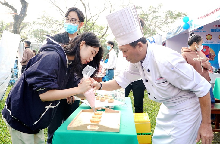 Học sinh tham gia chương trình tư vấn tại Quảng Nam trải nghiệm làm bánh, chơi trò chơi ở các gian tư vấn - Ảnh: LÊ TRUNG