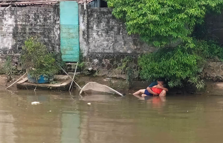 Người cha gào khóc ôm chặt đứa con chết đuối dưới sông - Ảnh 1.