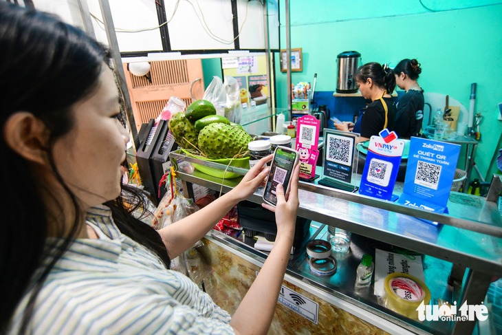 Với nhiều người trẻ, điện thoại thông minh là chiếc ví có thể thay thế mọi hoạt động cần đến tiền mặt - Ảnh: QUANG ĐỊNH