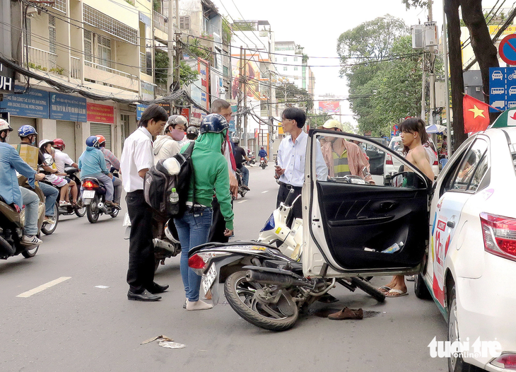 Lái xe taxi mở cửa bên trái không quan sát gây tai nạn cho người đi xe máy cùng chiều - Ảnh minh họa: T.T.D.