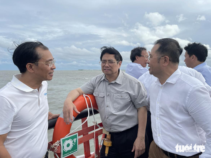 Thủ tướng Phạm Minh Chính trao đổi với Tổng giám đốc Cảng Sài Gòn Nguyễn Lê Chơn Tâm và Tổng giám đốc công ty tư vấn thiết kế cảng kỹ thuật biển Port Coast Phạm Anh Tuấn, yêu cầu  đảm bảo tiến độ siêu cảng Cần Giờ - Ảnh: VIỄN SỰ