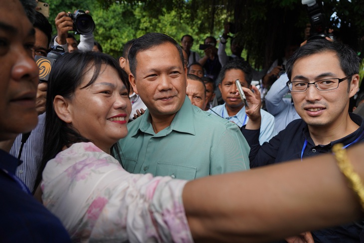 Ông Hun Manet chụp ảnh cùng người dân Phnom Penh sau khi bỏ phiếu. Trước ngày bầu cử, ông Hun Sen từng tuyên bố trên truyền hình: &quot;Trong 3 hoặc 4 tuần nữa, Hun Manet có thể trở thành thủ tướng. Điều đó phụ thuộc vào việc Hun Manet có làm được hay không&quot; - Ảnh: AFP