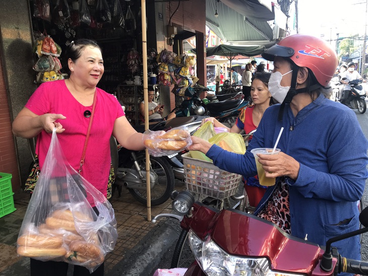 Dọc các tuyến đường và đền thờ ông bà Đỗ Công Tường, người dân tổ chức phát đồ ăn và nước uống miễn phí - Ảnh: ĐẶNG TUYẾT