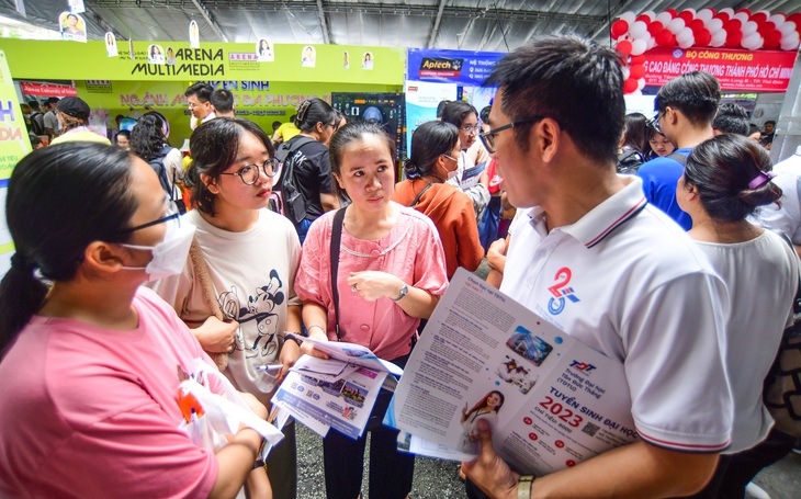 Thí sinh và phụ huynh tìm hiểu thông tin tại gian tư vấn của Trường ĐH Nguyễn Tất Thành tại Ngày hội tư vấn lựa chọn nguyện vọng xét tuyển đại học, cao đẳng 2023 ở Trường ĐH Bách khoa (ĐHQG TP.HCM) vào sáng 22-7 - Ảnh: QUANG ĐỊNH