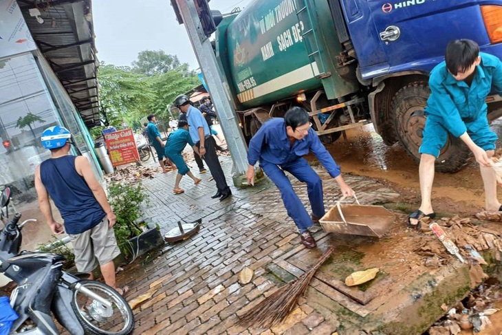 Huy động công an, quân đội hỗ trợ người dân bị ngập lụt ở Bình Phước - Ảnh 1. Lực lượng chức năng và người dân dọn dẹp nhà cửa, đường sá sau trận ngập lớn - Ảnh: AN BÌNH