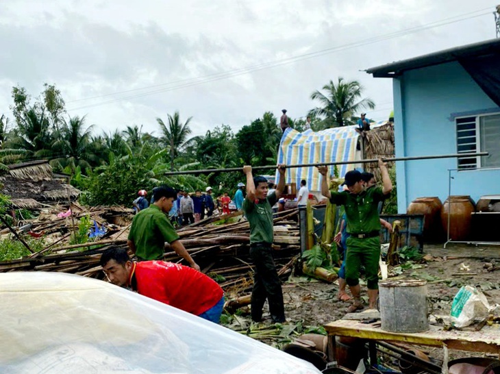 Lực lượng công an địa phương xuống hỗ trợ dân dọn dẹp, di dời đồ đạc - Ảnh: T.MINH