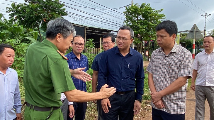 Lãnh đạo Công an huyện Chư Pưh thông tin về vụ tai nạn giao thông liên quan xe của CLB Hoàng Anh Gia Lai với ông Khuất Việt Hùng tại hiện trường vụ tai nạn - Ảnh: ĐÌNH CƯƠNG