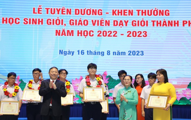 Bà Nguyễn Thị Lệ, chủ tịch HĐND TP.HCM (áo dài xanh) và ông Dương Anh Đức, phó chủ tịch UBND TP.HCM, tặng bằng khen cho học sinh giỏi, giáo viên tiêu biểu ngày 16-8 - Ảnh: Sở GD-ĐT TP.HCM