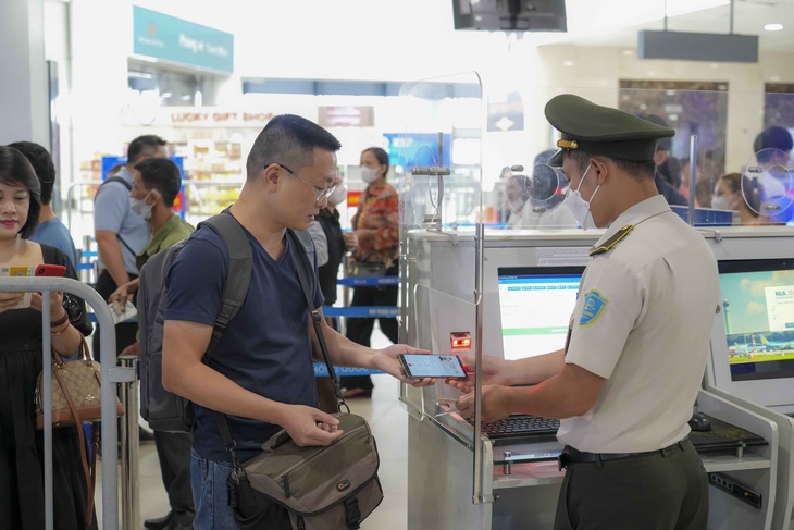 Hành khách sử dụng VNeID mức độ 2 để thay thế giấy tờ đi máy bay tại sân bay Nội Bài - Ảnh: NIA