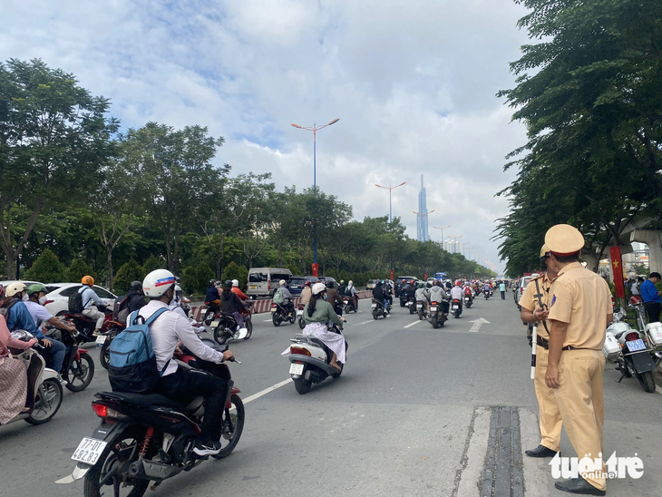 Lực lượng cảnh sát giao thông phân luồng phục vụ buổi lễ đổi tên đường - Ảnh: THU DUNG