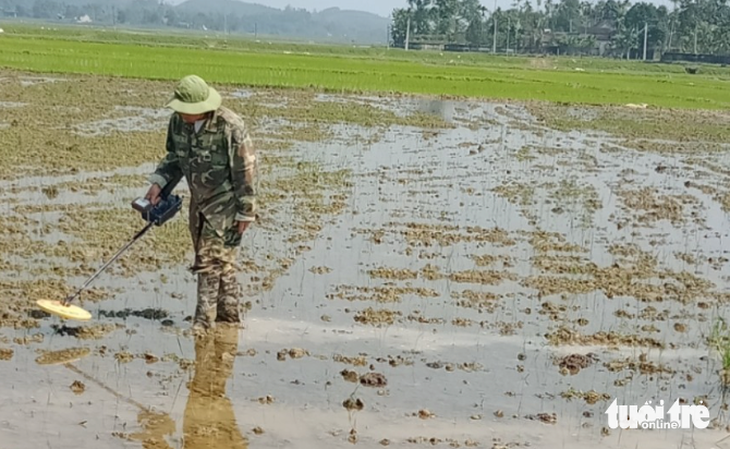 Địa phương phải thuê máy về rà kim loại ở thửa ruộng nhà ông Sỹ - Ảnh: N.THẮNG