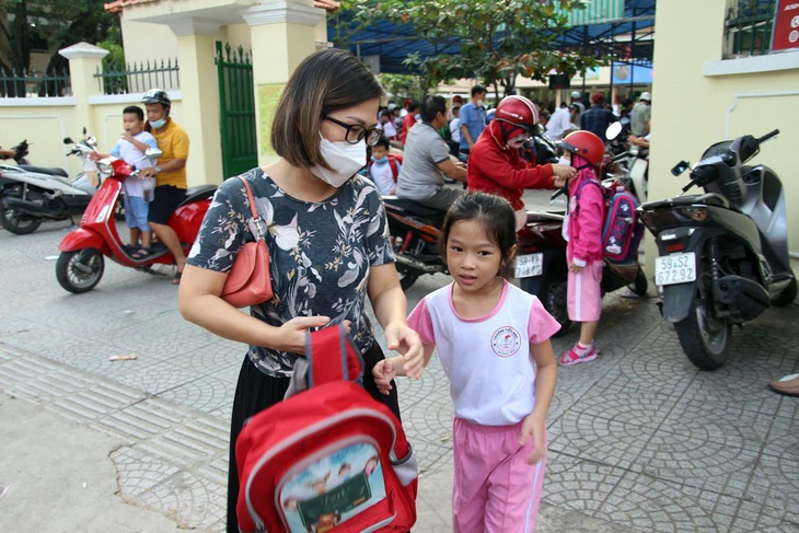 Phụ huynh đón con trong giờ tan trường. Năm nay, học sinh tiểu học ở TP.HCM dự kiến sẽ tựu trường vào ngày 22-8 - Ảnh: PHƯƠNG QUYÊN