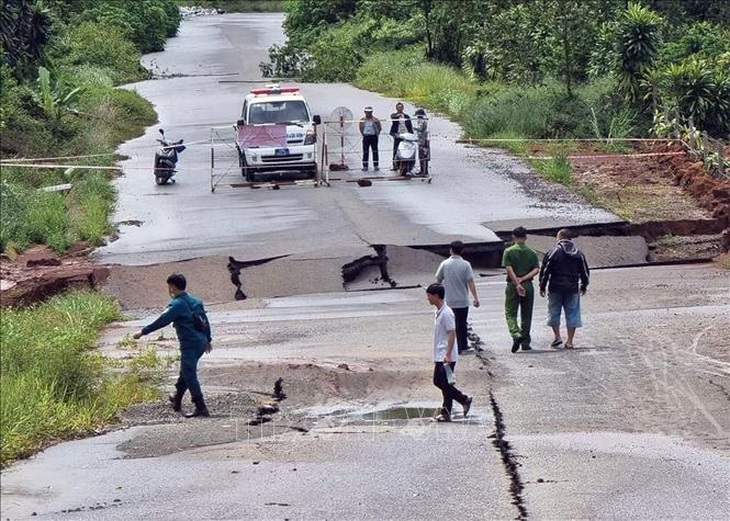 Lực lượng chức năng phong tỏa đoạn đường bị sụt lún - Ảnh: TTXVN 