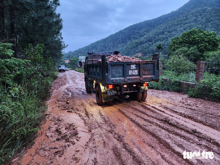 Xe tải được huy động vào hiện trường chở bùn đất ra ngoài - Ảnh: QUANG VIỄN