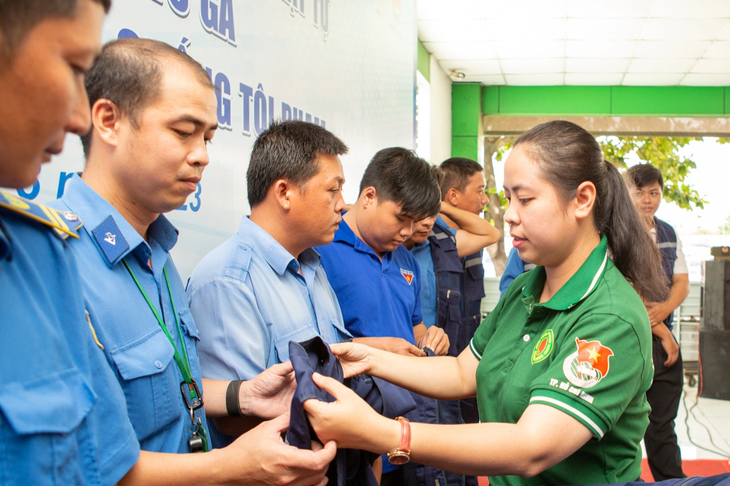 Phó bí thư Thành Đoàn TP.HCM Trịnh Thị Hiền Trân trao đồng phục cho đội phản ứng nhanh tại bến xe An Sương (huyện Hóc Môn) - Ảnh: Thành Đoàn