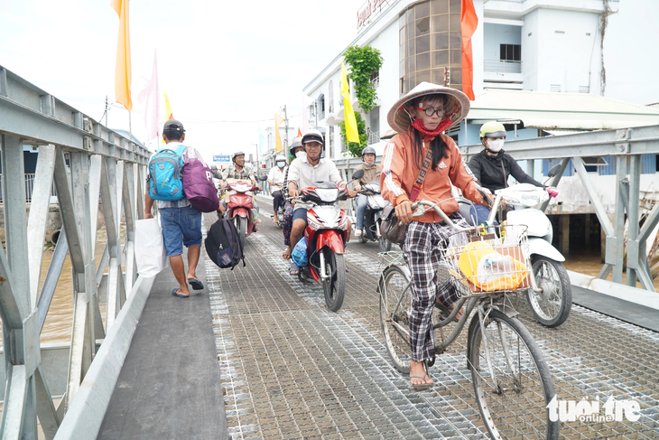 Người đi xe đạp, người bộ hành chọn đi phà thay cho đi cầu Vàm Cống vì quá xa - Ảnh: CHÍ HẠNH