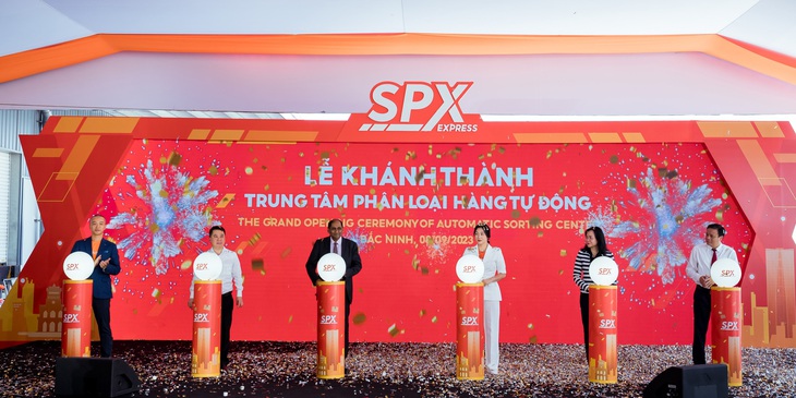 Các đại biểu cùng lãnh đạo SPX và khách mời bấm nút khánh thành trung tâm phân loại