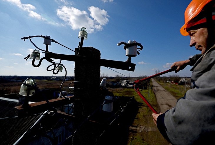 Một công nhân sửa cột điện tại Pravdyne, vùng Kherson, Ukraine, ngày 23-2 - Ảnh: REUTERS