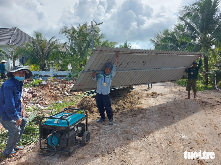 Công nhân di dời các vật dụng từ một căn biệt thự bị cưỡng chế ra khỏi hiện trường - Ảnh: CHÍ CÔNG