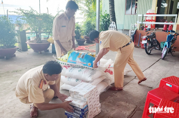 Lực lượng công an kiểm đếm số thuốc lá và đường cát - Ảnh: TIẾN VŨ