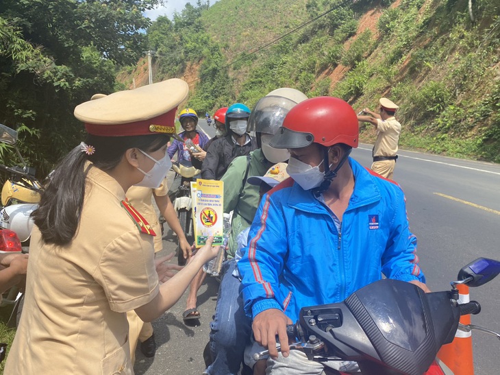 Ngoài tặng nước, CSGT còn tuyên truyền cho người chạy xe máy về quê nghỉ lễ - Ảnh: TẤN VŨ