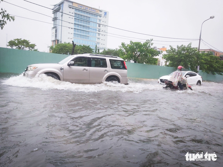 Ô tô, xe máy lội nước bì bõm trên đường Núi Thành gần đoạn giao đường 30-4 - Ảnh: ĐOÀN CƯỜNG