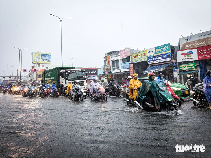 Dòng xe chen lấn di chuyển trên phần lòng đường ít ngập nhất trên đường Tôn Đức Thắng - Ảnh: TẤN LỰC